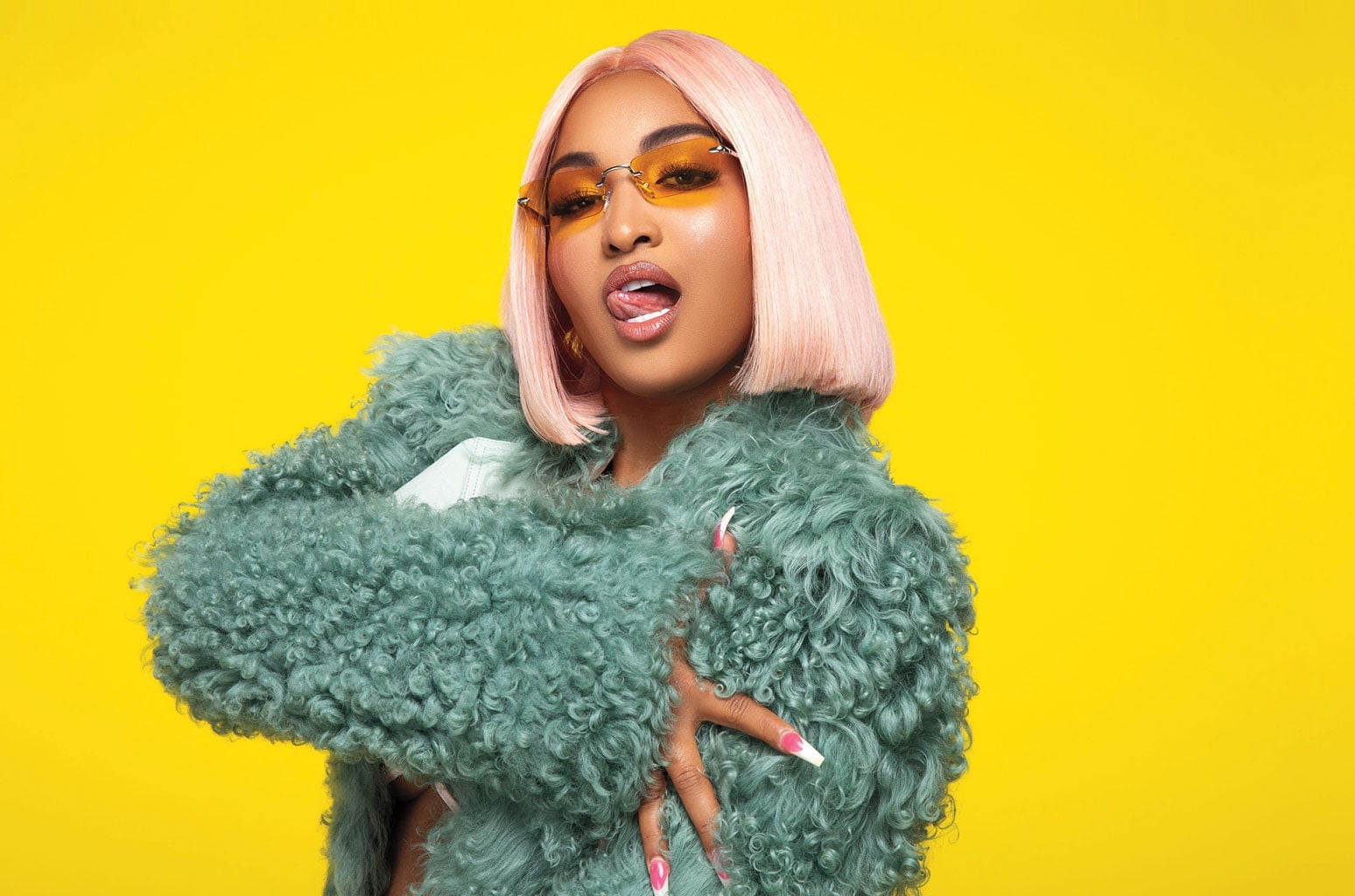 Shenseea posing with pink and orange hair